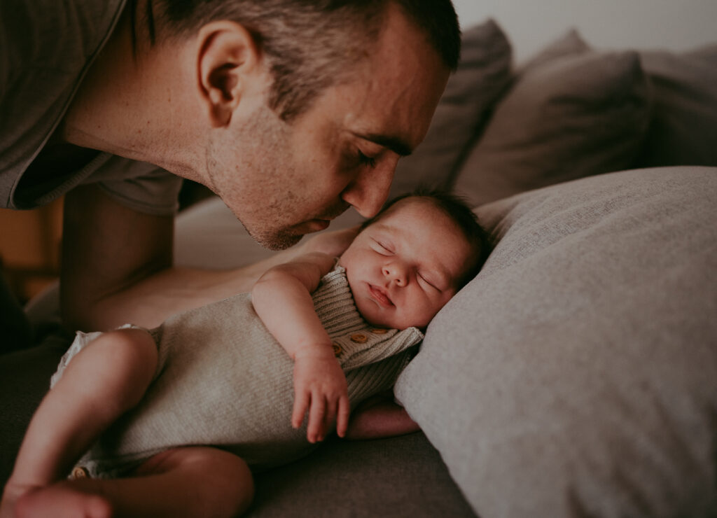 Papa und sein neugeborenes Baby beim Newbornshooting